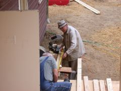 Men at work. Bob Herbst and Dave Venske cut lumber to size to feed the wall building crew.