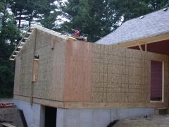 The next layer begins. The first two roof trusses comprising the over hang on the back go up.